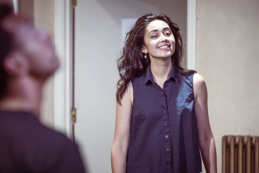 A close up of a smiling woman with her hair down and light on her face